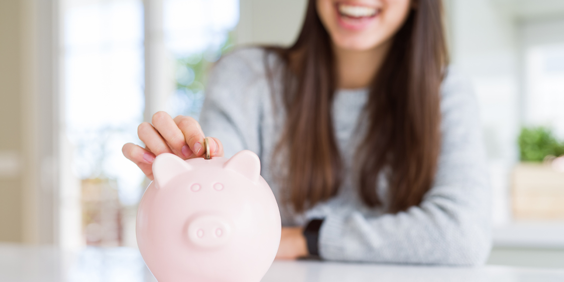 woman with her hand on a piggy bank