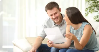 two person holding a paper in their hands and smiling