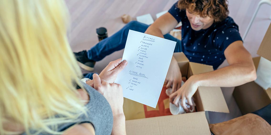 couple using checklist to pack moving boxes