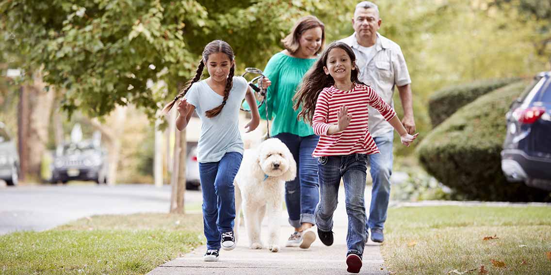 Family walking dog through neighborhood