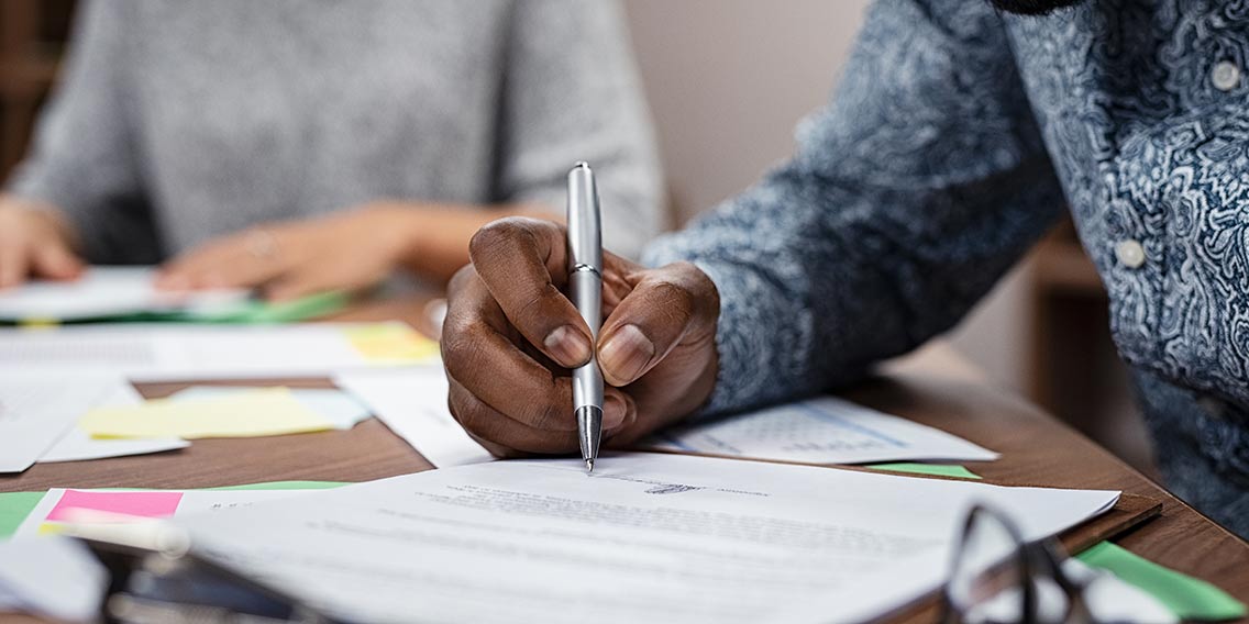 man holding a pen and signing papers