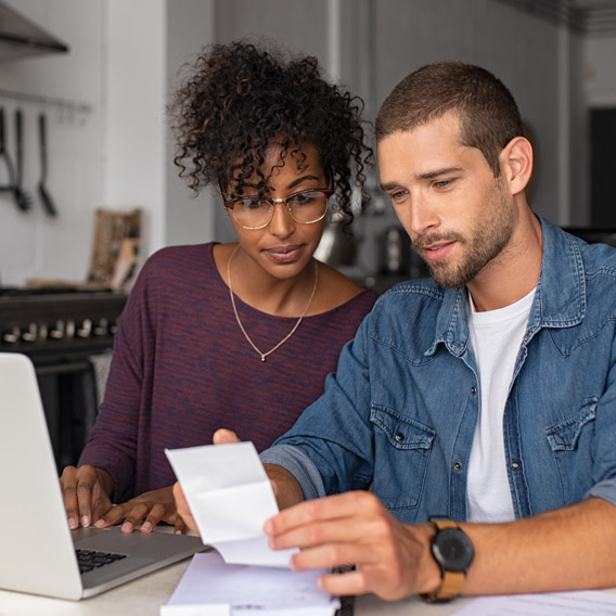 wife and husband discussing in front of laptop