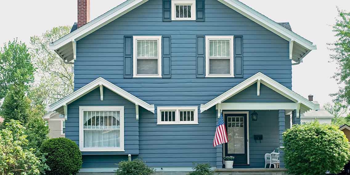 Blue home with American flag on porch