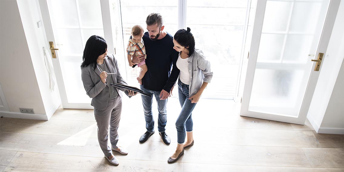 couple with child talking to real estate agent