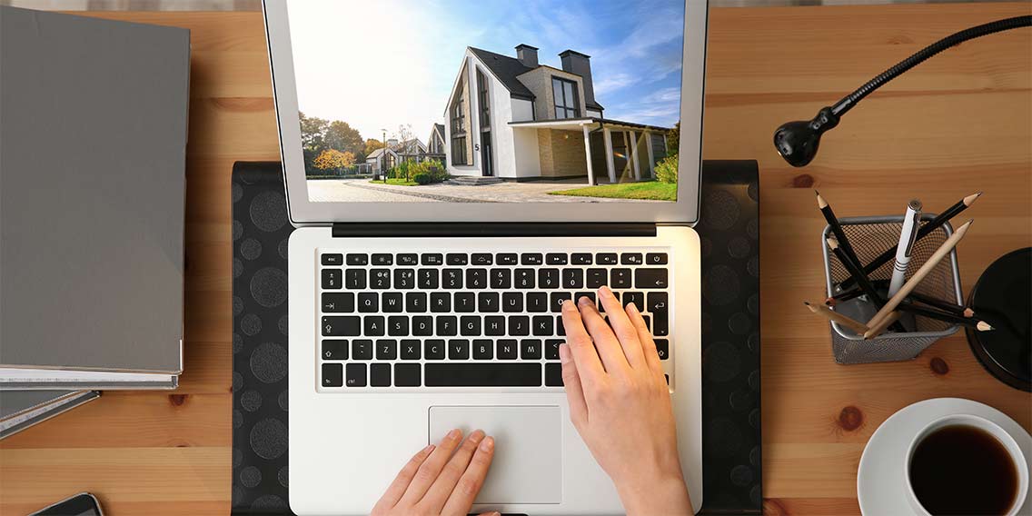 ome buyer researching homes on laptop