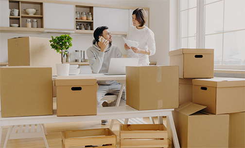 couple with boxes in office space