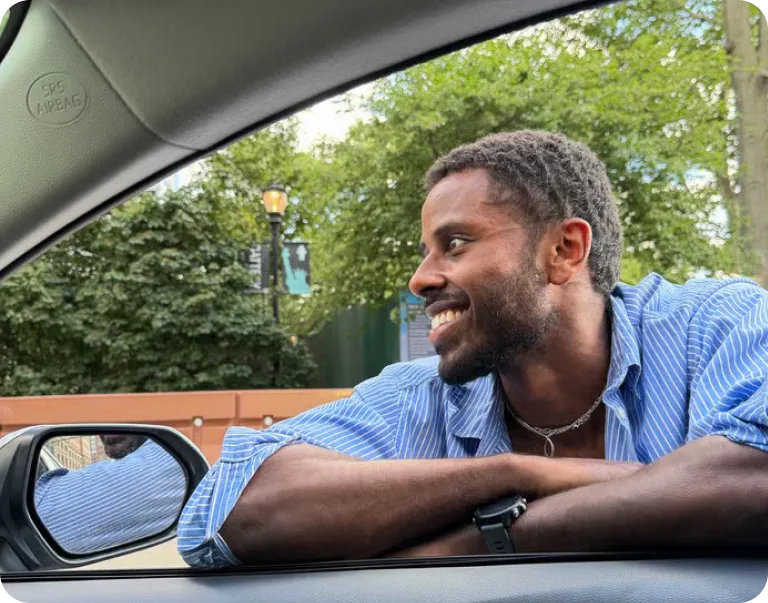  Close-up front view of a person standing outside near the car window.