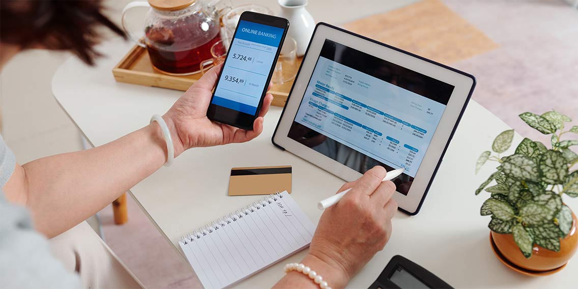 woman holding calculator and writing on paper