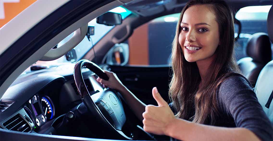 a girl showing thumbs up while sitting in a car