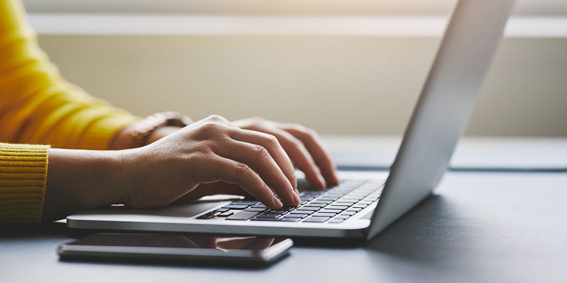 hands typing at computer