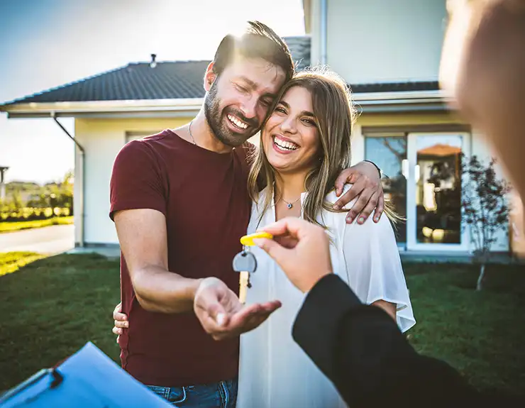 Happy millennial couple receiving keys from realtor, purchasing real estate - Family meeting with real estate agent - New house and real estate concept