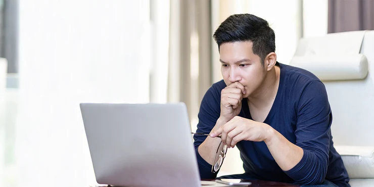 man researching va loans on laptop