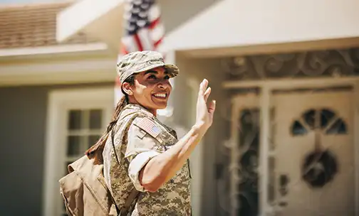 Child with American flag running up steps of home.