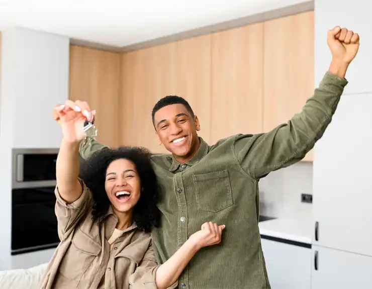 happy couple holding keys to new house