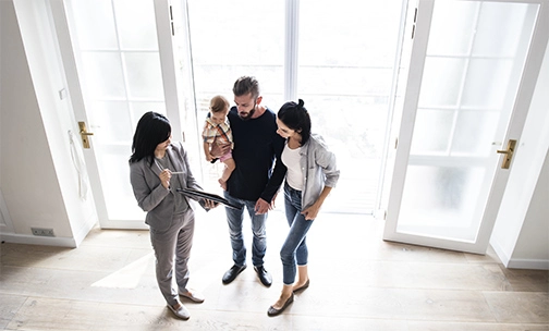 couple with child talking to real estate agent