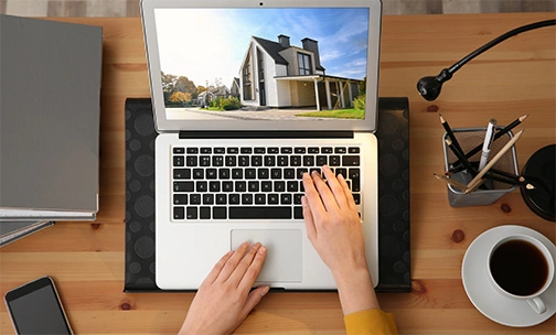 Home buyer researching homes on laptop