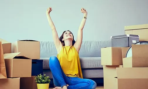 Happy young woman moving to new home and having fun