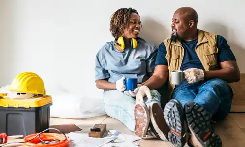 Couple sitting on the floor and having coffee.