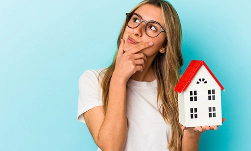 curious woman with a house in her hand