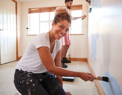 a woman painting her interior home wall blue