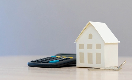 calculator, house and key on table