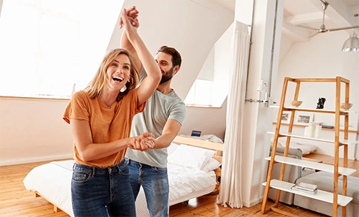 Man and woman dancing in their hew home.