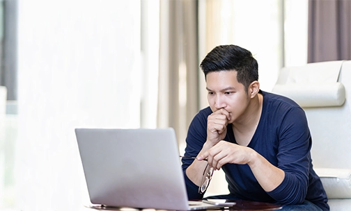 man researching va loans on laptop