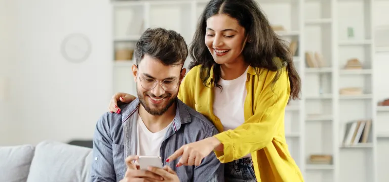 Couple viewing mobile phone to opt out on promotional emails