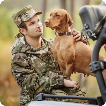 A military man looking at a dog