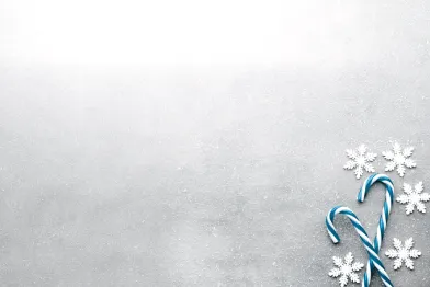 Decorative holiday tile featuring blue and white striped candy cane with delicate, stylized snowflakes.