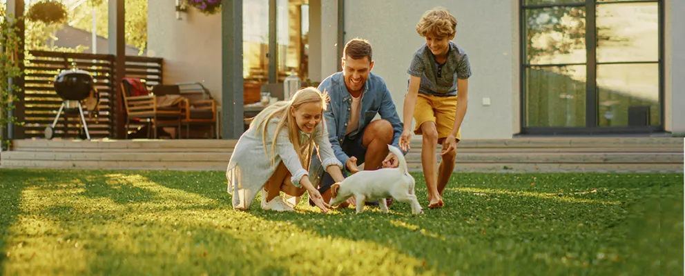 family playing with dog in yard