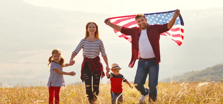 Family running while holding the American Flag