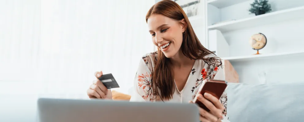 a lady smiling while holding a card in hand