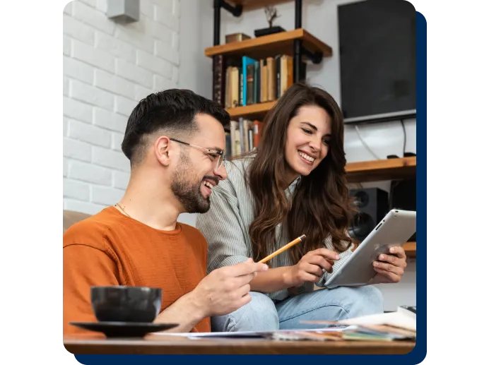 a couple working on tablet and smiling