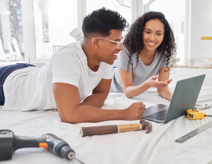 couple renovating home and checking computer