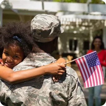 An army man holding his child