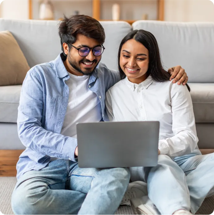 a couple on laptop searching about buying their first home