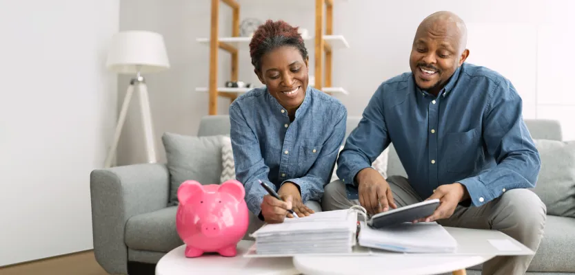 Couple discussing the papers and Piggy bank placed on the side