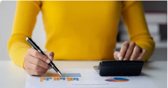 lady holding a pen and using calculator for some graph calculations