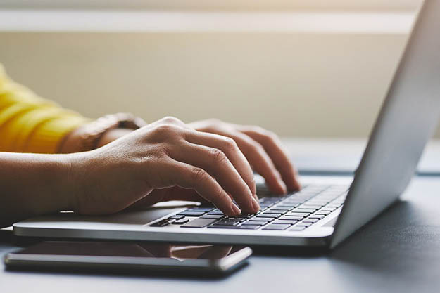Hands typing at a computer.