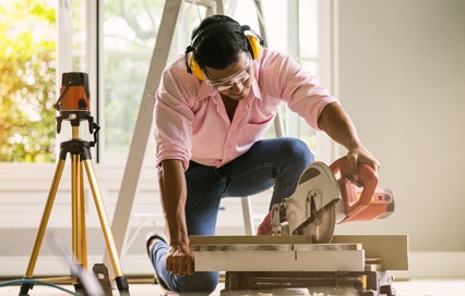 man cutting wood for a house project