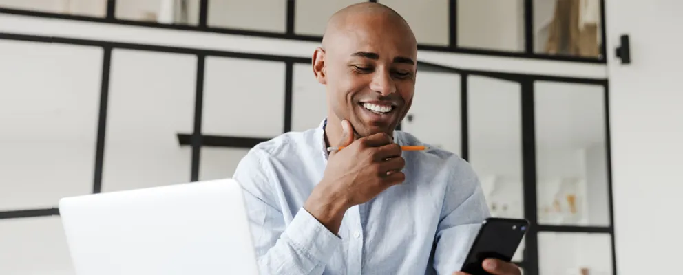 Gentleman smiling while viewing his mobile device