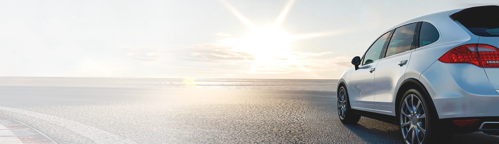 white sport utility vehicle driving into a sunset
