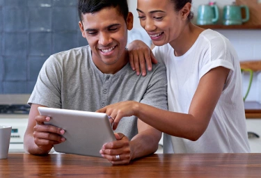 couple looking at ipad while smiling