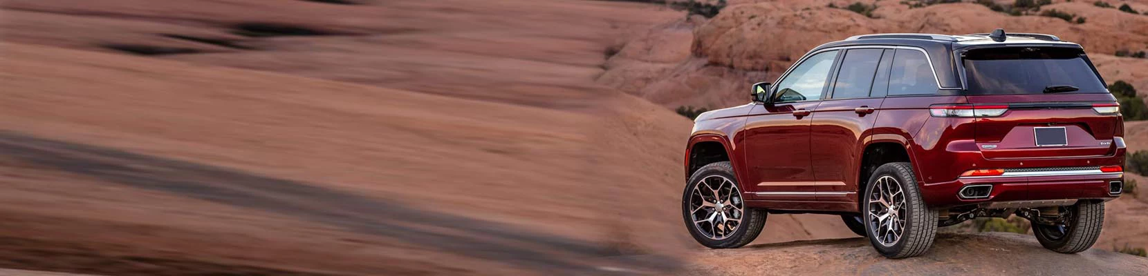 red sport utility vehicle on top of a hill