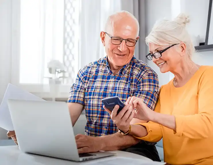 couple researching on the computer and phone