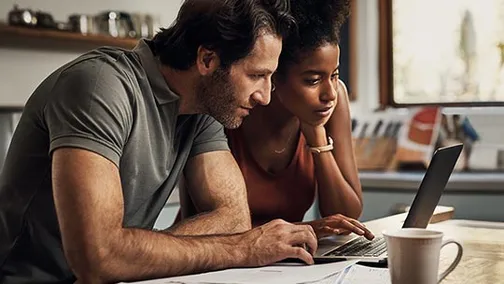 couple sitting at table using a laptop