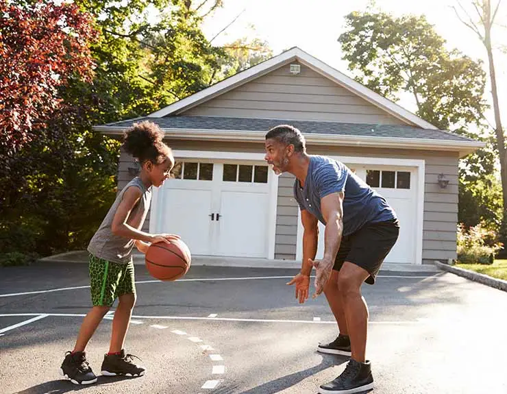father and child playing basketball