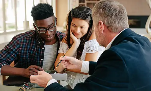 young couple in discussion with real estate agent