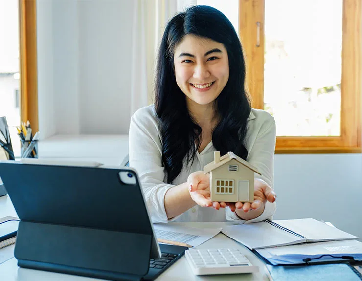 woman holding wooden house